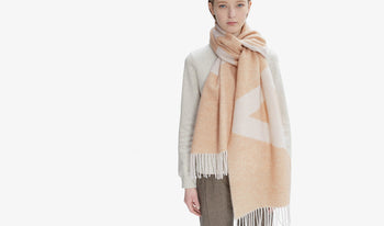 A.P.C. Women's Scarves - Woman wearing multicolor scarf and matching sweater.