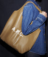 A.P.C. Accessories Black Friday - Woman wearing denim shirt holding brown Ninon tote bag.