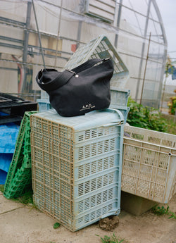Black journal bag on top of plastic crates