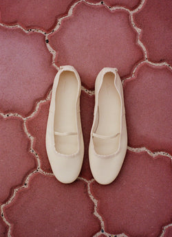 White ballet flats on pink tiles