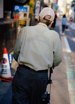 Old man with walker walking down street in Japan