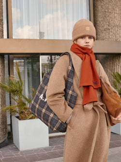 A.P.C. The Brand - Woman wearing wool coat, scarf, and beanie standing in front of university building.