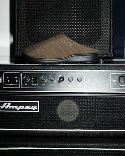 A.P.C. x Subu - Green Subu sandal on amplifier.