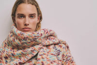 A.P.C. Women's Gift Me More - a woman model wearing a chunky, multi-colored sweater against an off-white background