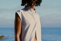 Woman with curly hair in dress on a beach