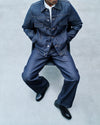 A.P.C. Raw Selvedge Indigo Denim Journal Entry - Man wearing denim jacket and jeans sitting on chair.