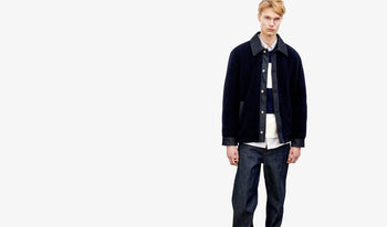 A.P.C. Men's Shirts - Man wearing white corduroy shirt and brown pants standing in kitchen.