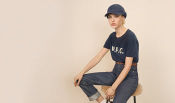 A.P.C. Women Sale T-shirts, Tops - Woman standing on bridge in coat and jeans.