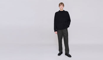 A.P.C. Men's Pants & Shorts - Man wearing patterned swim trunks on a patio.
