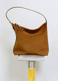 A.P.C. Vera Bags - Camel suede Vera bag sitting on tile stand.