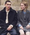 A man and a woman sitting side by side in A.P.C. apparel