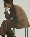 A.P.C. New Arrivals - man pensively sitting on a stool