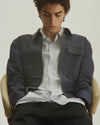 A.P.C. Men - man sitting in A.P.C. clothing with hands in pocket