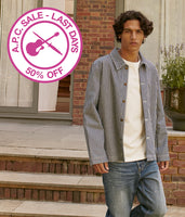 Person standing outdoors with a summer sale sign in the corner