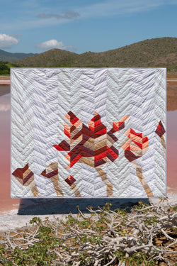 Quilt suspended above small lake and branches