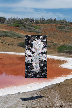 Quilt suspended above small lake