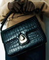 A.P.C. Embossed Leather - Woman holding black embossed Astra bag.