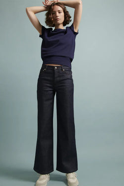 A.P.C. Denim - Woman wearing navy top with wide leg jeans.