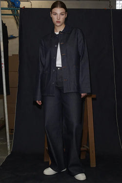 A.P.C. Denim - Woman wearing denim jacket and jeans standing in a photoshoot.