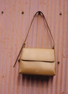 beige bag on a pink wall