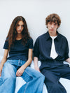 A.P.C. New Arrivals - a couple sitting against a wall in fall outfits