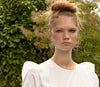 A.P.C. Women's New Arrivals - woman model in white dress with trees in the background