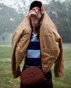Woman standing in the rain in a park wearing